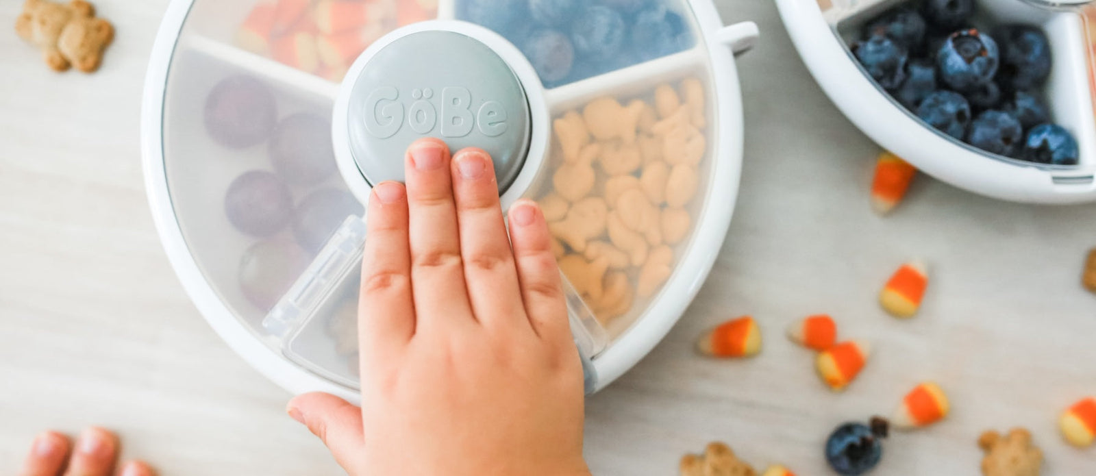 Small child hand pushing the button on a Snack Spinner