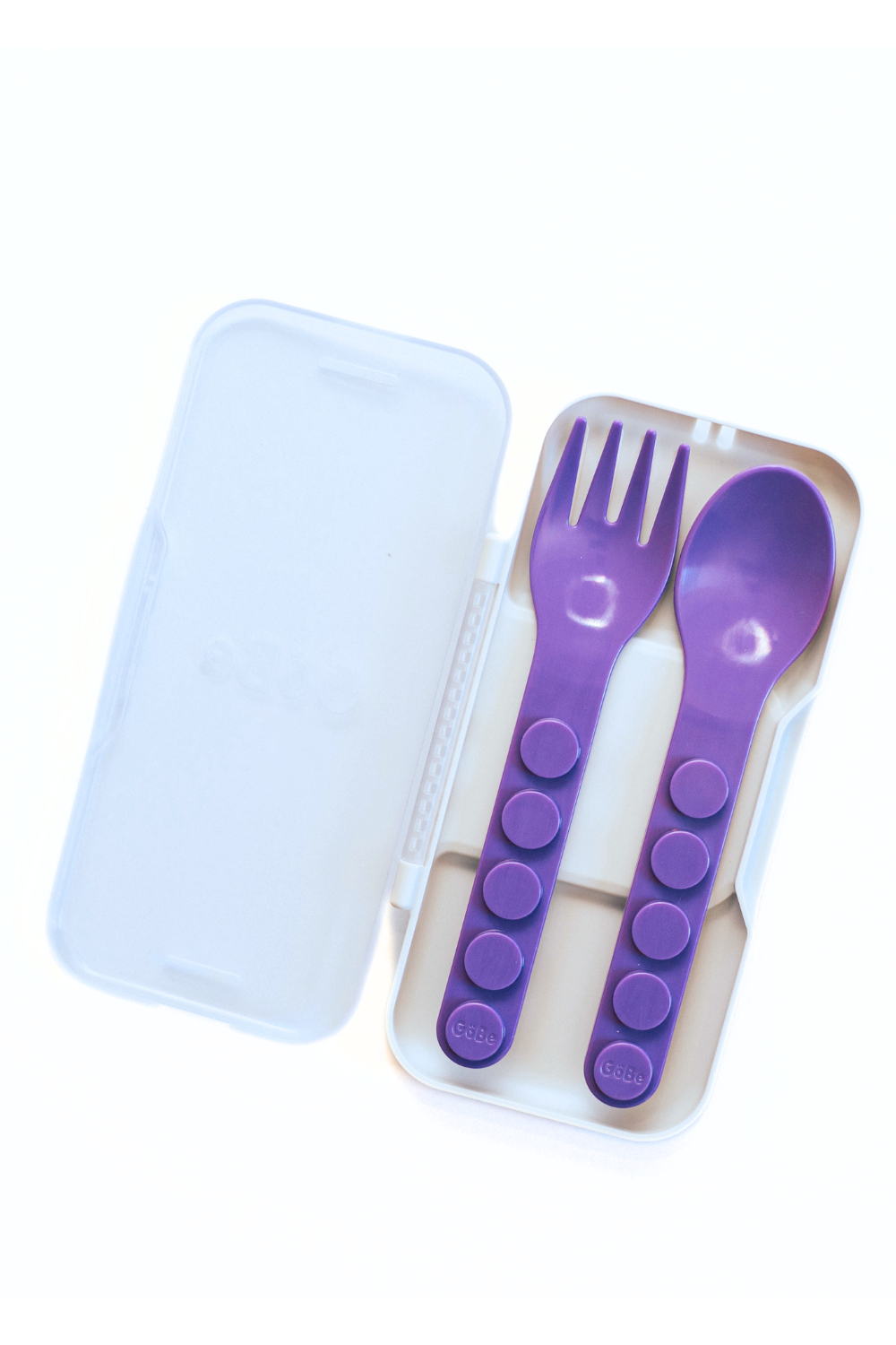 Purple fork and spoon set in a clear case on a white background