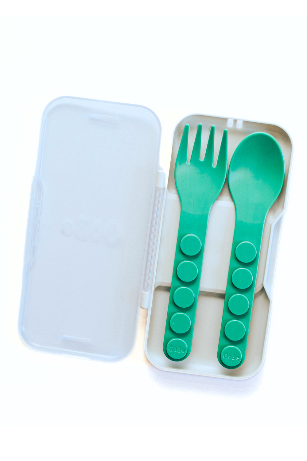 Green spoon and fork set in a clear case on a white background